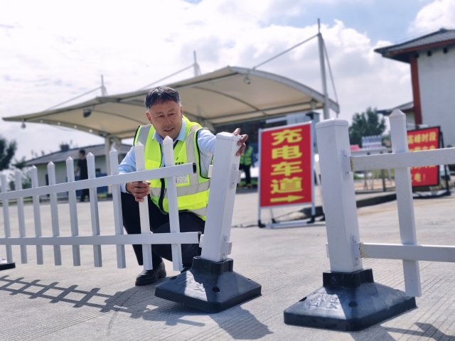 1759107300523728.jpg 為提升節(jié)假日期間通行效率,濉溪服務(wù)區(qū)在節(jié)前提前完成油電車道分離工作。圖為濉溪服務(wù)區(qū)物業(yè)安全職員王仲連在擺放隔離柵欄。.jpg